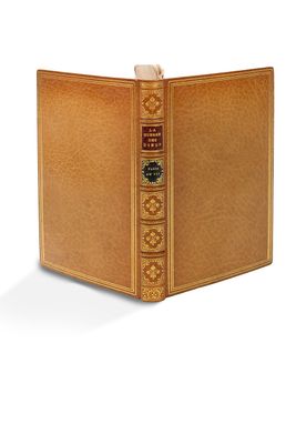 un vieux livre à la couverture dorée posé sur une surface blanche