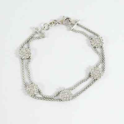 a close up of a silver bracelet on a white background