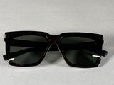 des lunettes de soleil noires posées sur une surface blanche, sur fond blanc