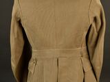 the back view of a tan jacket on a mannequin stand