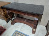 a small table with a black marble top on it