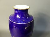 a blue vase with gold stars on it sitting on a table