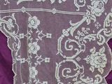 an image of a piece of white lace on a purple cloth