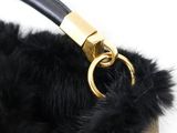 someone is holding a black purse with a gold handle