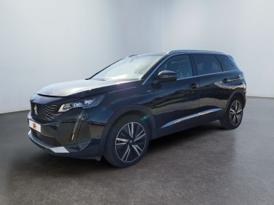 a blue car parked in a room with a white wall