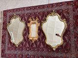 trois miroirs accrochés au mur, avec un tapis en arrière-plan