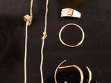 quelques bagues en or et d'autres bijoux sont posés sur une surface noire