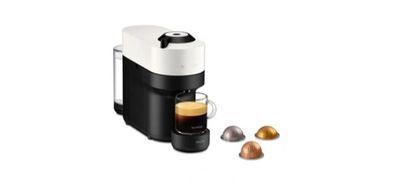 un gros plan d'une machine à café avec une tasse de café à côté