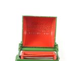 a green box with a red lid on a white surface