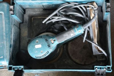 une boîte à outils bleue avec des outils sur le sol
