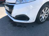 the front end of a white car parked in a parking lot