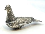 un oiseau argenté posé sur une surface blanche