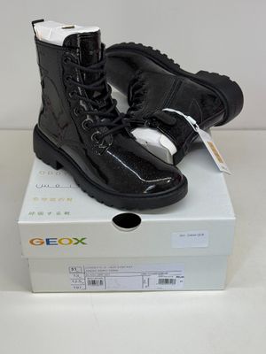 a pair of black boots sitting on top of a box