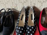 three pairs of black and white polka dot shoes sitting on top of a red box