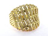 gros plan d'une bague en or avec des diamants sur une surface blanche