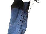 pair of blue jeans with laces hanging on a hanger