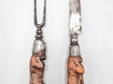 two forks and a knife on a white surface