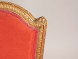 an image of a red and gold chair against a white wall