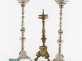 a pair of silver candlesticks on stands with a green tag