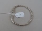 a silver bracelet that has a tag on it