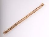 a close up of a gold bracelet on a white surface