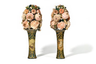 two vases with flowers in them on a white surface