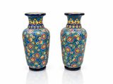 une paire de vases bleus ornés de motifs floraux sur fond blanc