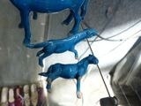 three blue horses that are hanging from the ceiling
