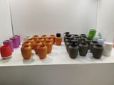 many different colored vases sitting on a white shelf