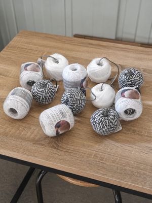 many balls of yarn sitting on a table next to each other
