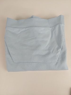 le haut d'un pull bleu clair est replié sur une table
