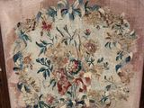 a chair with a floral tapestry on the back of it