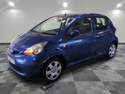 la photo d'une petite voiture bleue sur un sol en damier