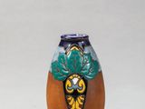 un petit vase orné d'un motif, posé sur une table