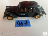 une petite voiture noire sur laquelle est apposé un insigne de police