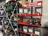 une voiture garée dans un garage, à côté d'une étagère remplie d'outils