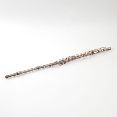 an old silver flute with a wooden handle on a white surface
