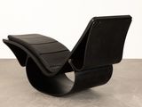 an image of a black chair sitting on top of a cement floor
