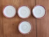 quatre tasses et soucoupes posées sur une table en bois