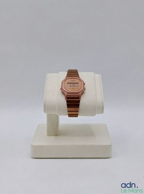 une montre posée sur un présentoir, sur une surface blanche