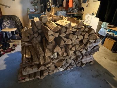 a pile of wood sitting in a garage next to a chair