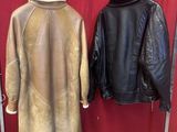 two leather jackets hanging on a rack in front of a red wall