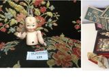 deux photos représentant une poupée et une valise posées sur une table