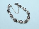 a close up of a bracelet on a table with a chain