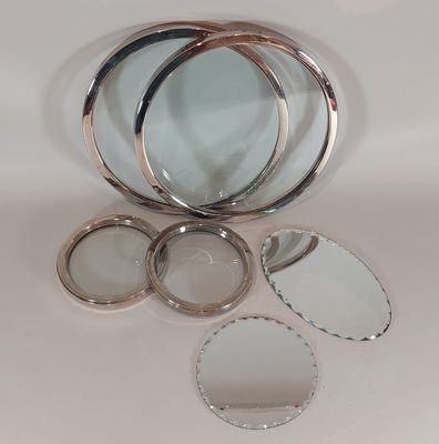 Plusieurs types de miroirs sont disposés sur une surface blanche