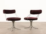 a pair of chairs with red velvet upholstered and chrome legs