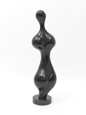 black sculpture of a female torso on a black base on a white background
