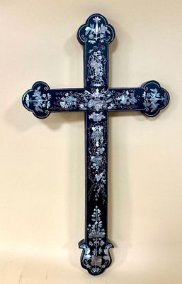 blue and white cross with floral design on it on a wall