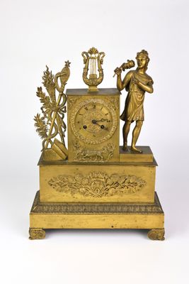 une horloge en or surmontée d'une statue