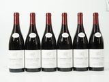 six bouteilles de vin rouge alignées sur une surface blanche